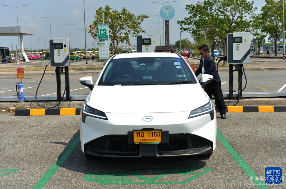 3月14日，在泰國曼谷素萬那普機場一處停車場，司機為一輛廣汽埃安電動出租車充電。新華社發(fā)（拉亨攝）