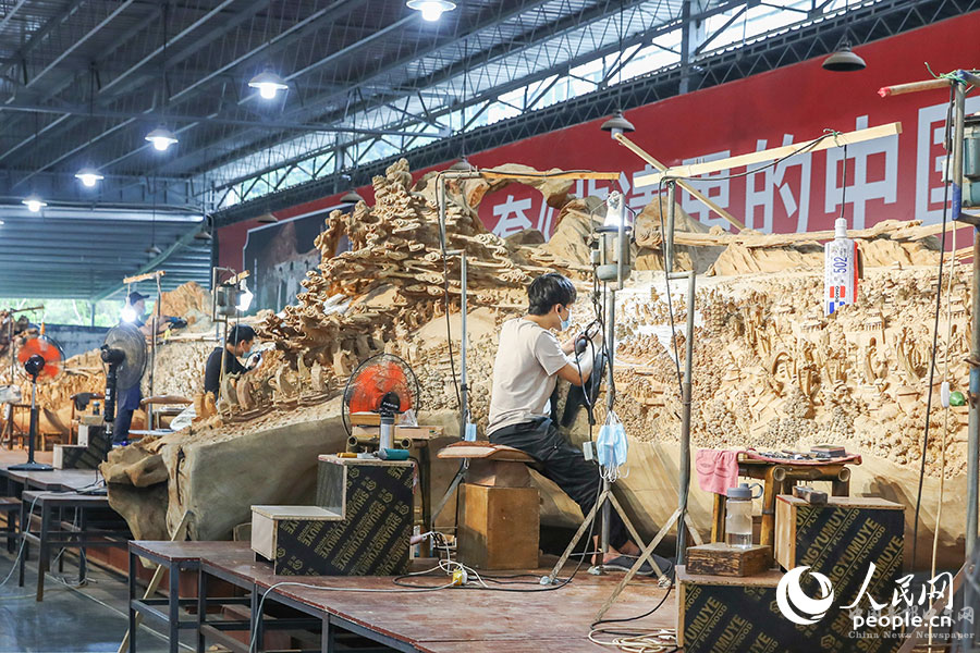 由國家級非遺項目莆田木雕代表性傳承人鄭春輝及其團(tuán)隊創(chuàng)作的超百米巨型作品《京杭大運(yùn)河》正在雕刻階段。人民網(wǎng) 陳永整攝